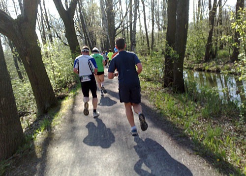 Läufer auf schmalem Weg zwischen Kanälen im Spreewald