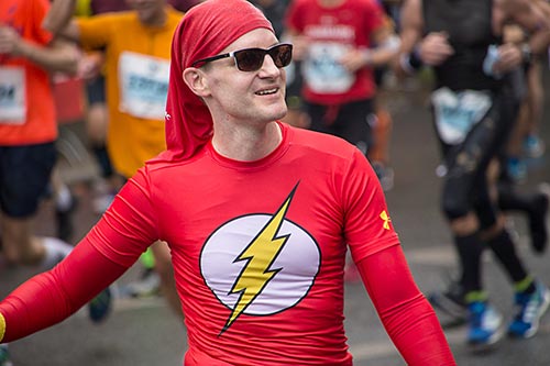 Tanzender Marathon-Läufer im Flash-Kostüm