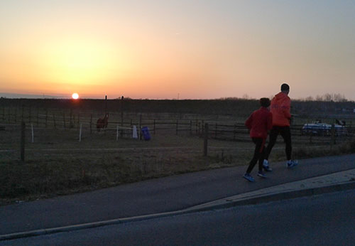 Läuferin und Läufer vor Sonnenaufgang