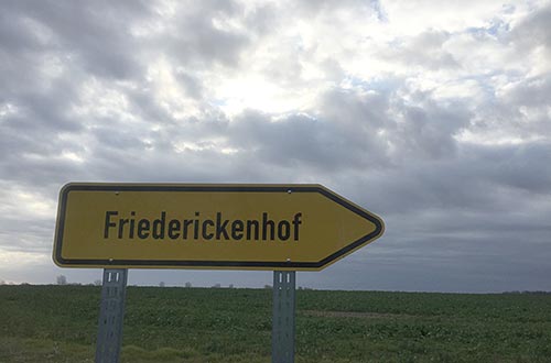 Schild Friederickenhof vor dichten Wolken