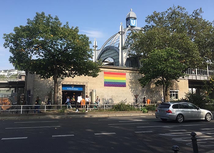 U-Bahnhof Nollendorfplatz mit Regenbogenfahne am Gebäude und Stahl-Glas-Kuppel