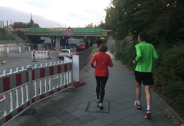 Läuferin und Läufer vor S-Bahn-Unterführung Marienfelde