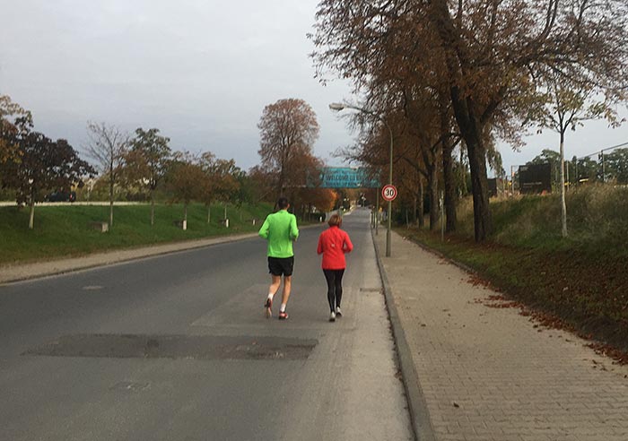 Läufer-Paar auf leerer Straße im Marienpark