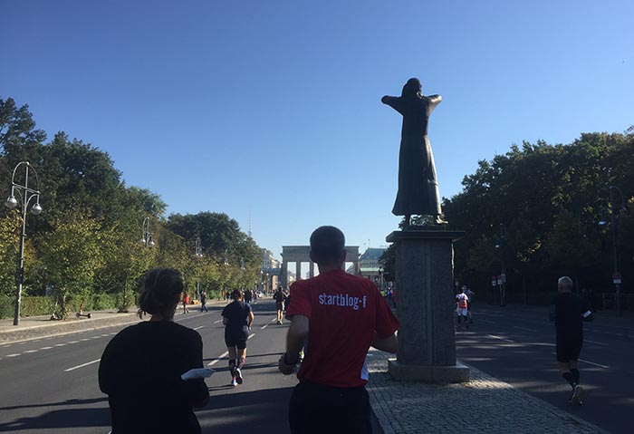 startblog-f-Läufer neben der Skulptur „Der Rufer“