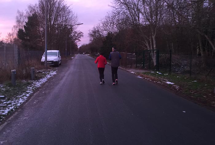 Läuferin und Läufer auf einsamer Straße