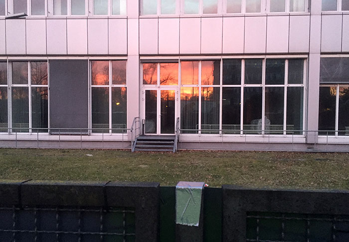 Feurig roter Sonnenaufgang in den Fenstern eines Bürogebäudes