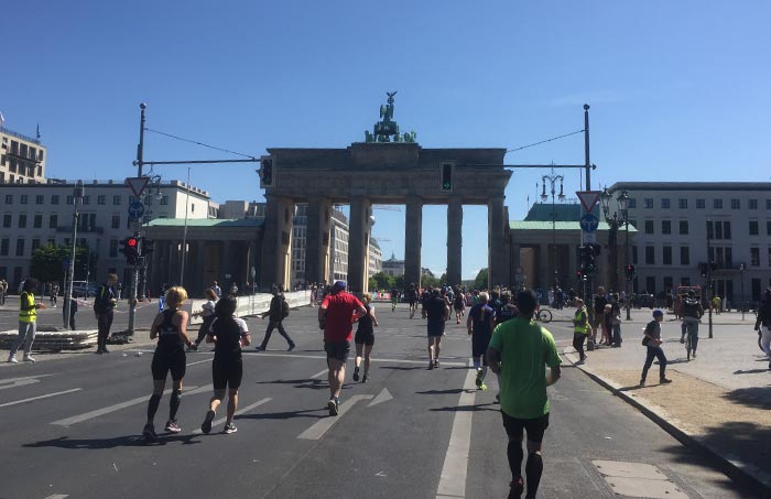 Teilnehmer*innen laufen auf das Brandenburger Tor zu