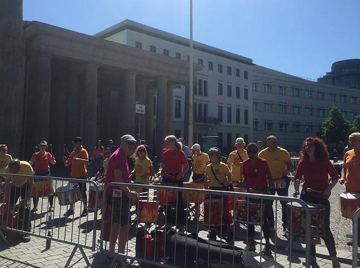 Trommelgruppe in gelben und roten Shirts am Brandenburger Tor