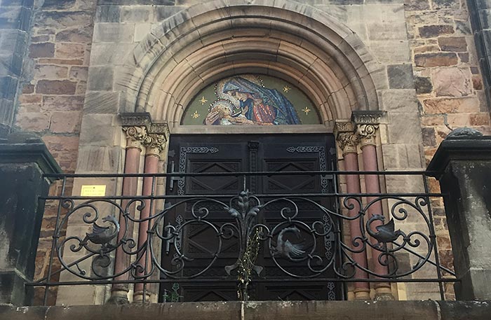 Eingang zu einer Kirche, darüber ein Mosaik mit Maria und dem Kind
