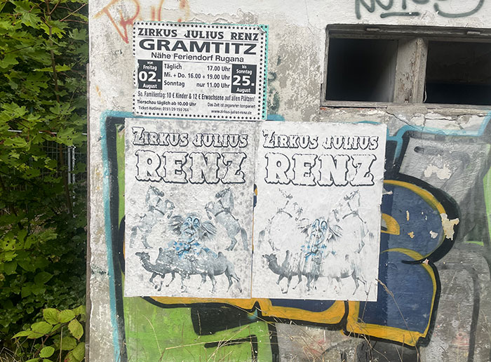 Vergilbte, fast farblose Plakate „Zirkus Julius Renz“ vor einer graffiti-besprühten Gebäudewand