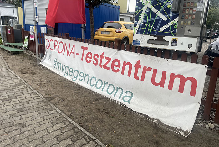 Banner an einem niedrigen Zaun „Corona-Testzentrum“