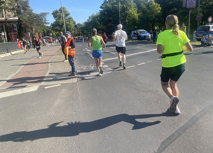 Läuferin in neongelbem Shirt kurz vor Ende der ersten Runde am Rathaus Reinickendorf