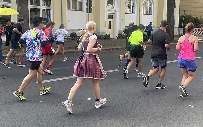 Läuferfeld, darunter eine Läuferin mit blondem Zopf im Dirndl