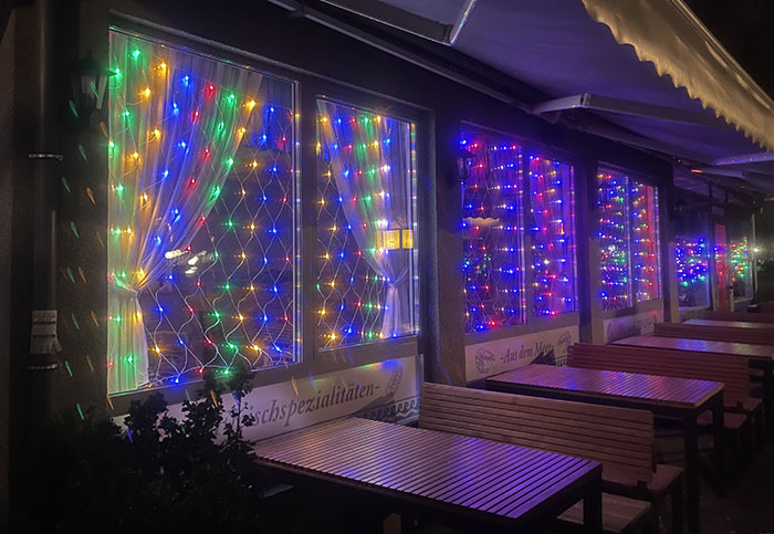 Leuchtdekoration mit vielen roten, gelben, grünen und blauen Lichtern an einem Restaurant