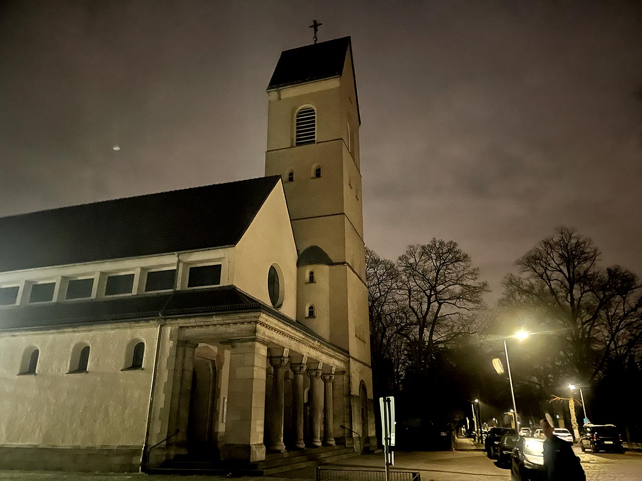Kirche mit Säulenvorbau und großem Kirchturm in der Morgendämmerung