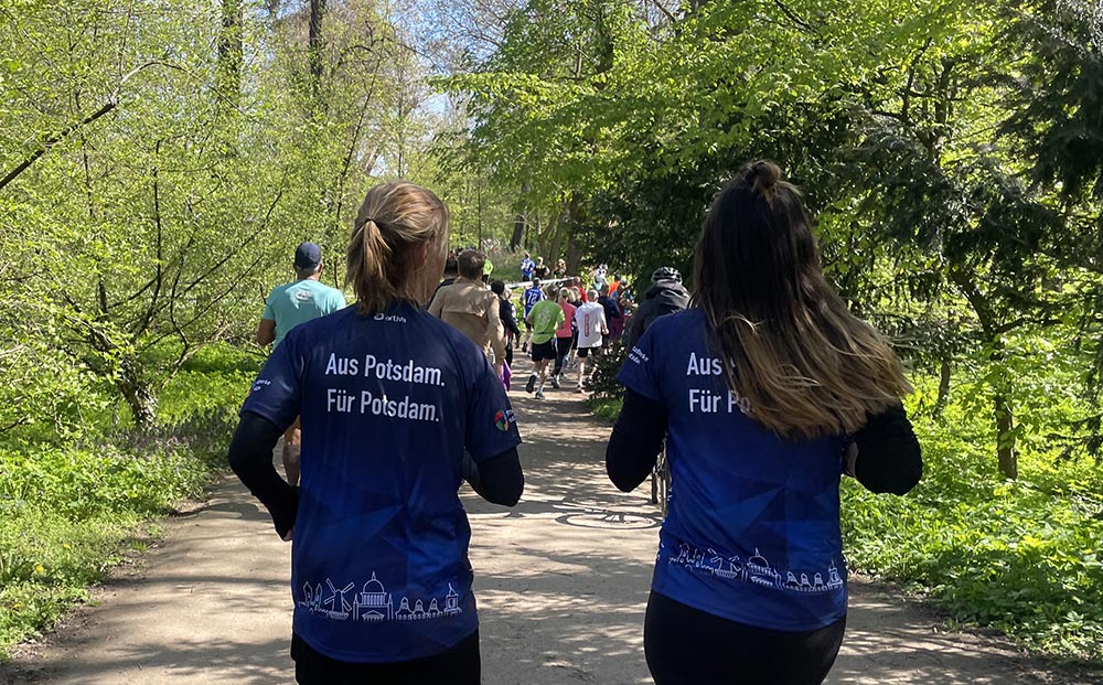 Läuferinnen mit dunkelblauen Laufshirts mit Text „Aus Potsdam. Für Potsdam.“