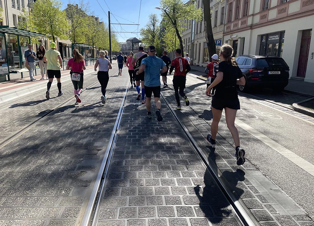 Läufer*innen auf Straße mit Tram-Schienen