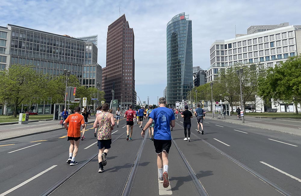 Läufer auf der Straße am Leipziger Platz mit Blick auf die Hochhäuser des Potsdamer Platzes