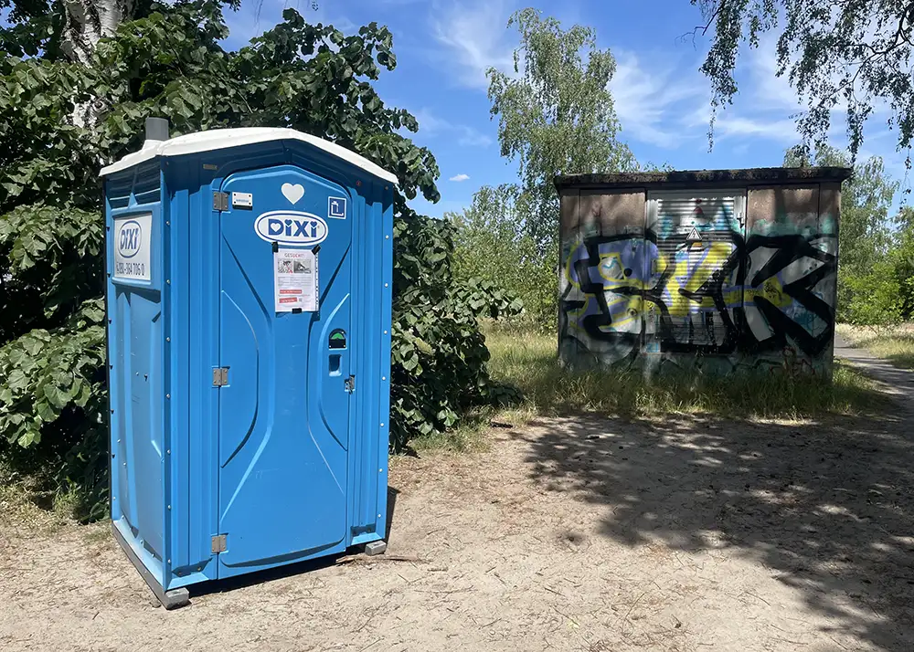 Blaues Dixi-Toilettenhäuschen am Wegesrand