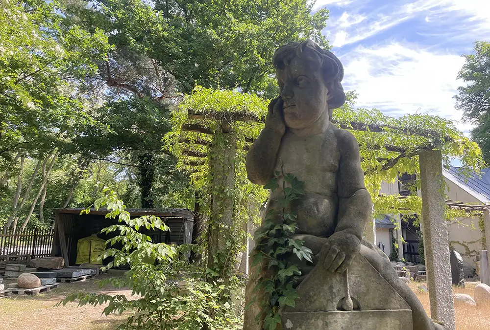 Skulptur eines nachdenklichen Jünglings im Garten des Friedhofssteinmetzen