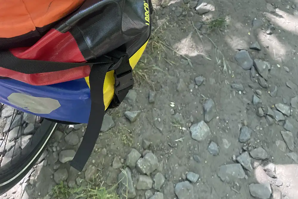 Fahrrad-Detail mit Blick auf den Boden mit groben Schottersteinen