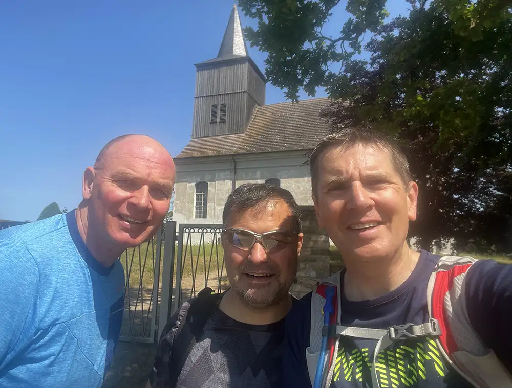 Selfie der drei Läufer/Radfahrer vor der Kirche Schlunkendorf