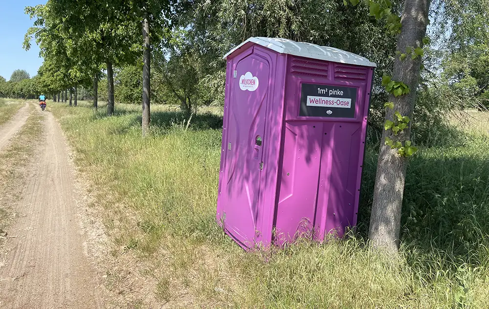 Rosa Toilettenhäuschen am Feldwegrand
