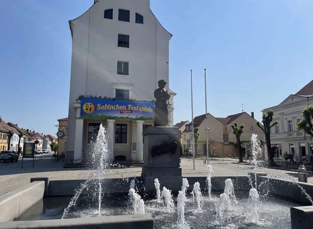 Springbrunnen mit Sabinchen-Denkmal, am Gebäude dahinter ein Banner für die Sabinchen-Festspiele