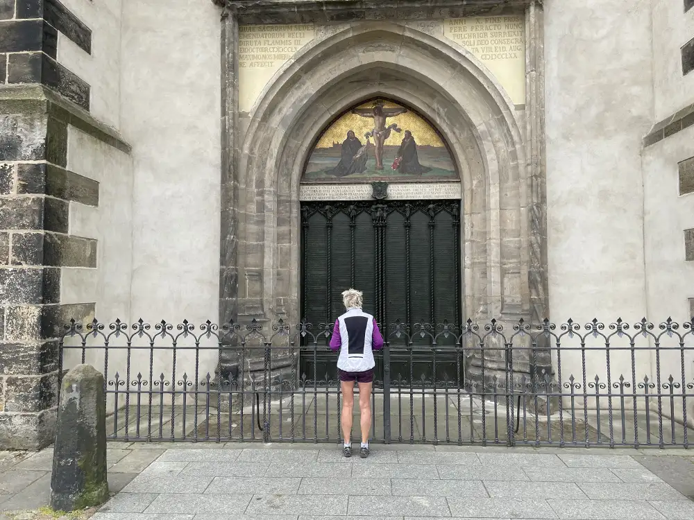 Einzelne Frau in Sport-Kleidung vor der Luther-Thesentür an der Schlosskirche Lutherstadt Wittenberg
