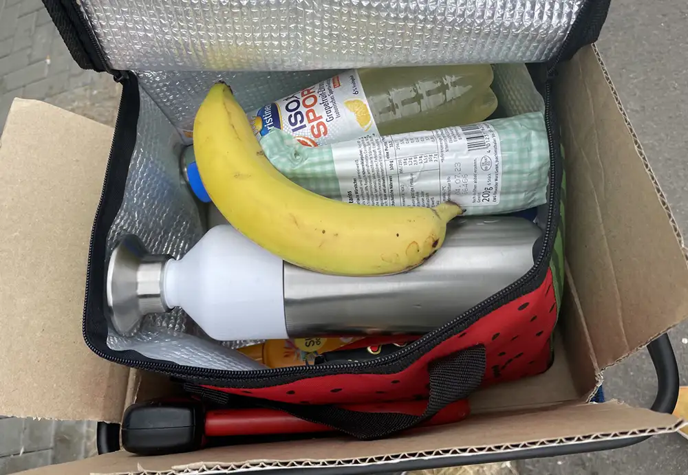 Blick in eine kleine Kühltasche mit Thermoskanne, Iso-Getränk und Banane