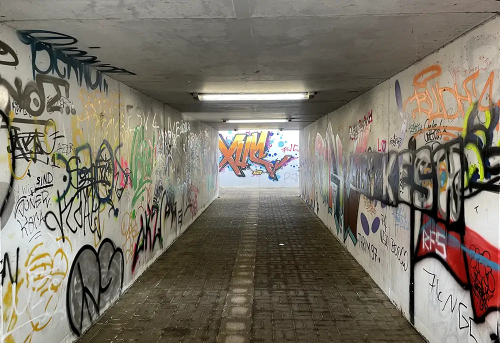 Graffiti-beschmierter Tunnel zwischen den Bahnsteigen