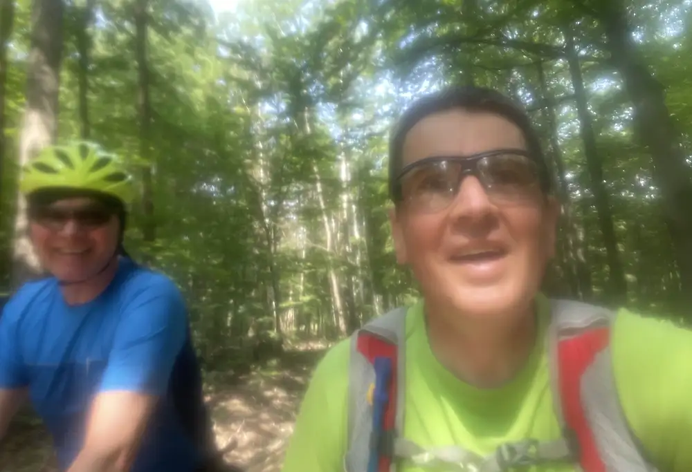 Etwas verschwommenes Selfie von Läufer und Radfahrer unterwegs im Wald