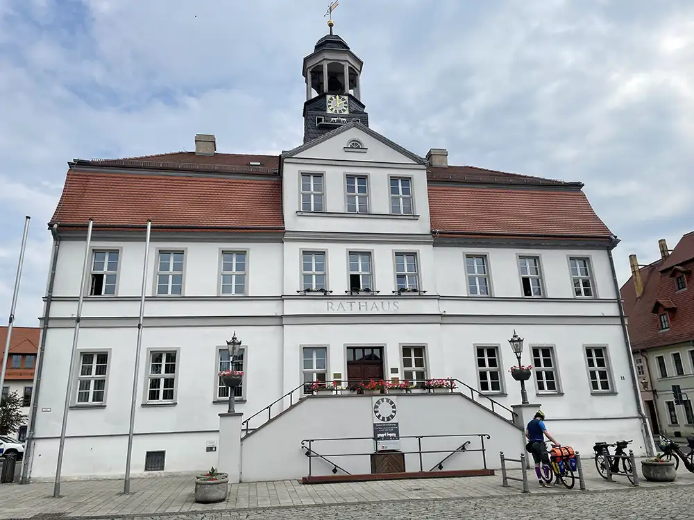 Rathaus in Bad Düben, unter der Turmuhr stoßen gerade zwei Ziegenböcke mit ihren Hörnern aneinander
