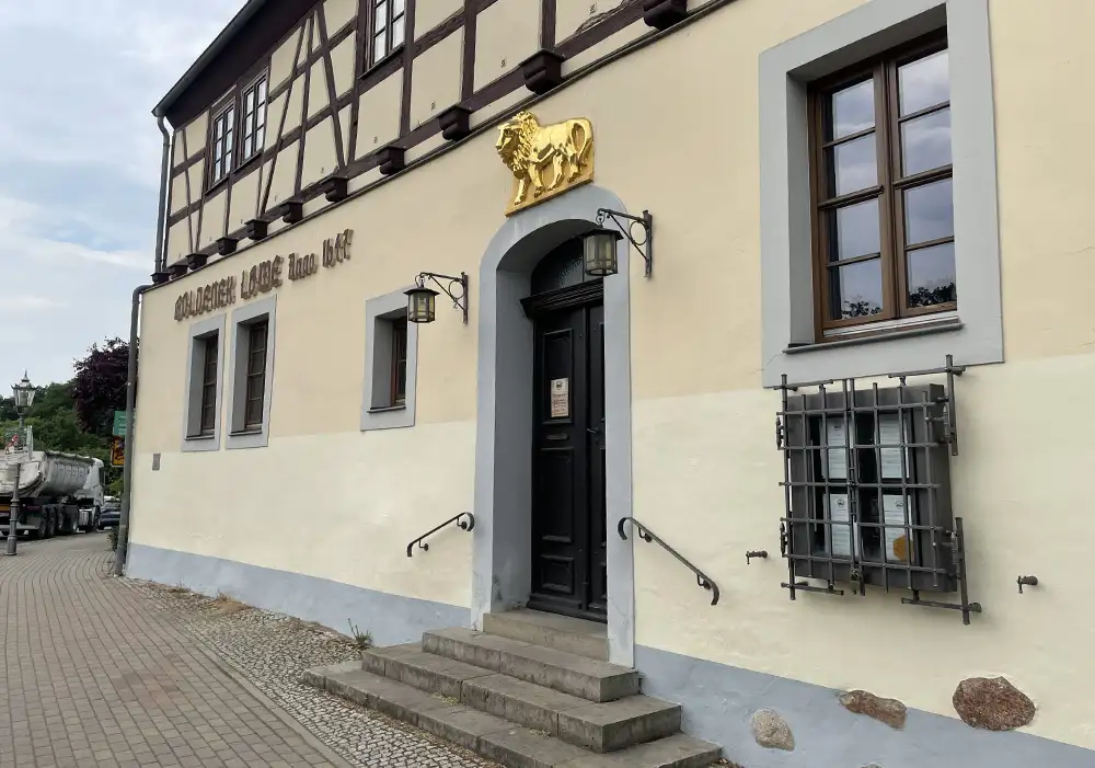 Fassade des historischen Gasthauses Goldener Löwe mit dem Relief eines goldenen Löwen über der Eingangstür