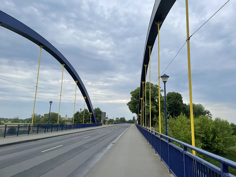 Brücke mit blauem Geländer und blauen Seitenbögen mit gelben Verstrebungen