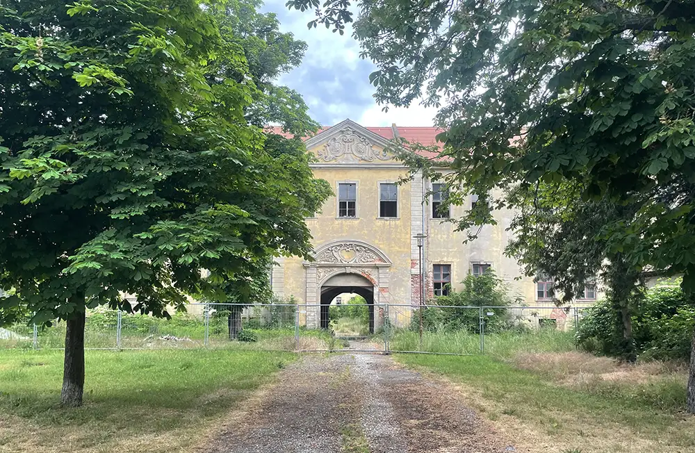 Schloss Wölkau mit Eingangsportal hinter Bauzäunen