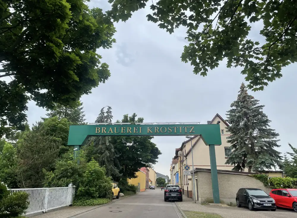 Großes grünes Tor über der Straße mit Aufschrift Brauerei Krostitz