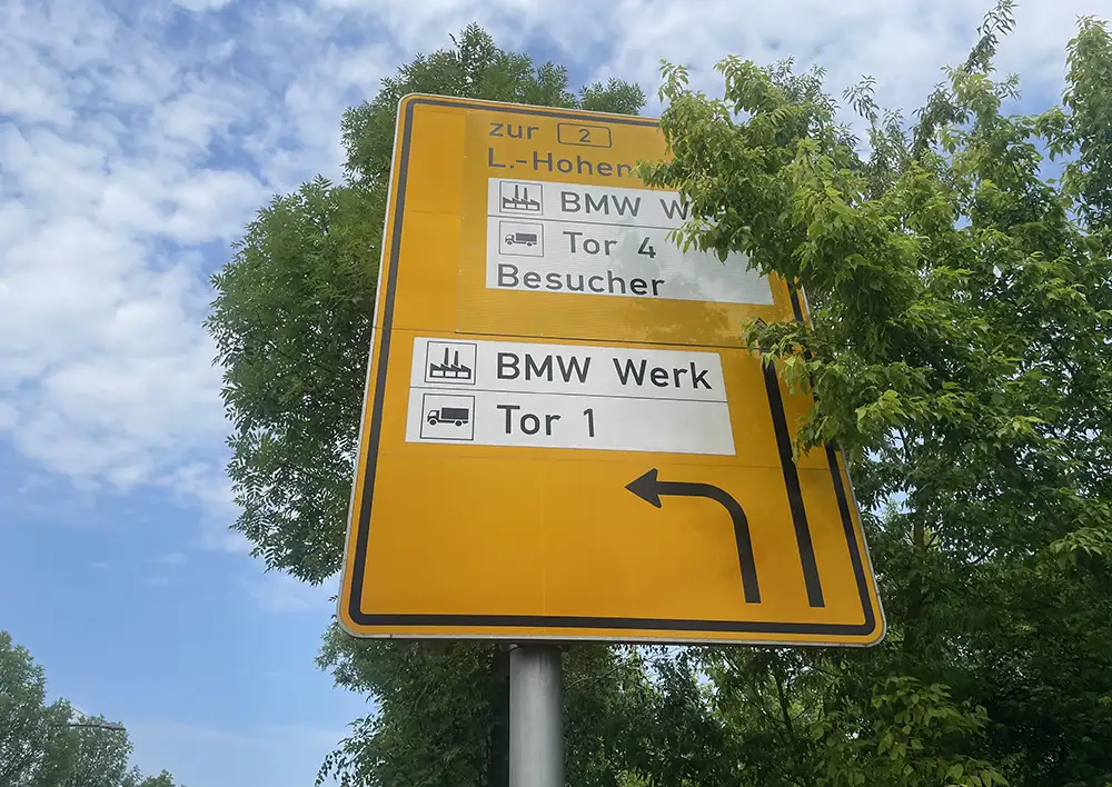 Großes gelbes Schild mit Hinweis zu den Toren 1 und 4 BMW Werk