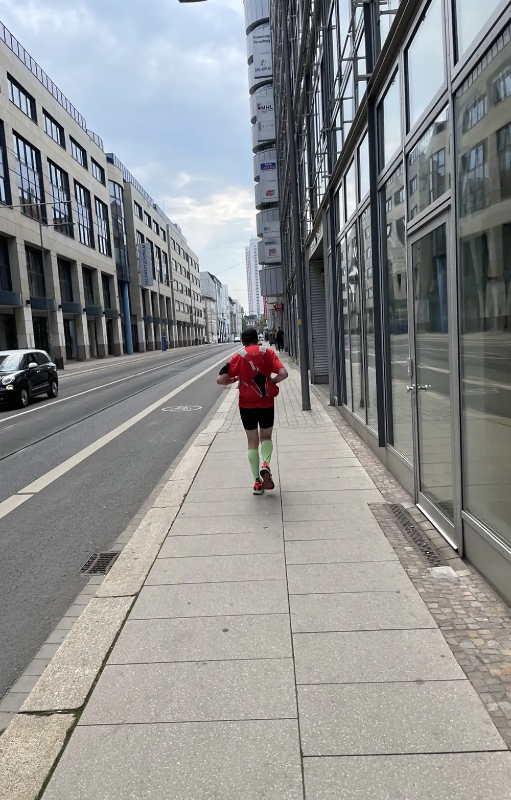 Läufer auf einem einsamen schmalen Fußweg zwischen Bürogebäuden