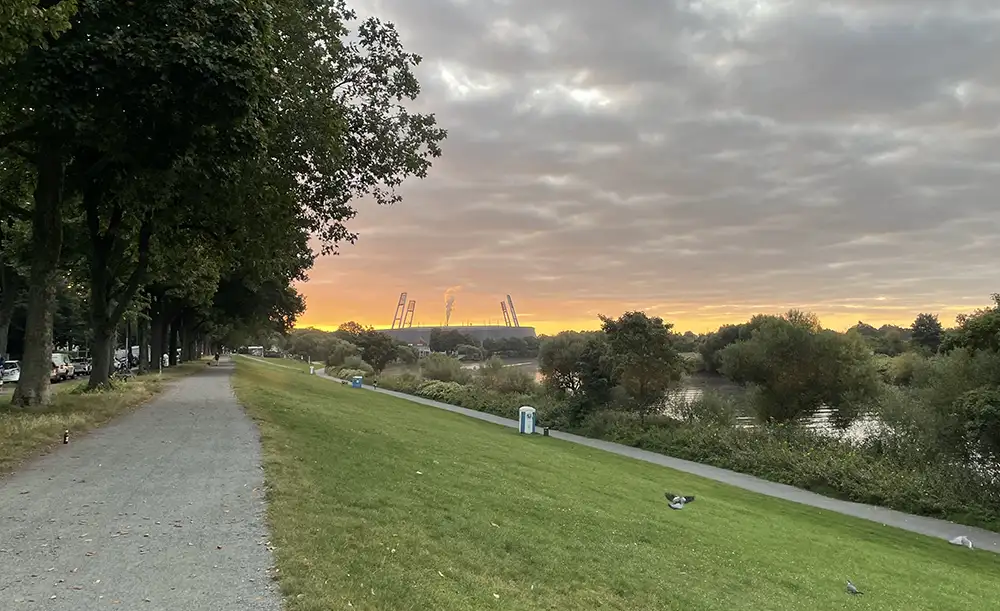 Osterdeich an der Weser, im Hintergrund das Weserstadion vor dem Sonnenaufgang