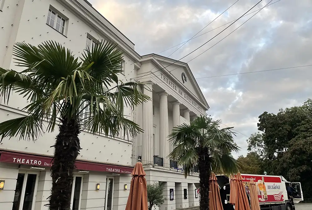 Theater am Goetheplatz mit klassizistischen Säulen, im Vordergrund Palmen