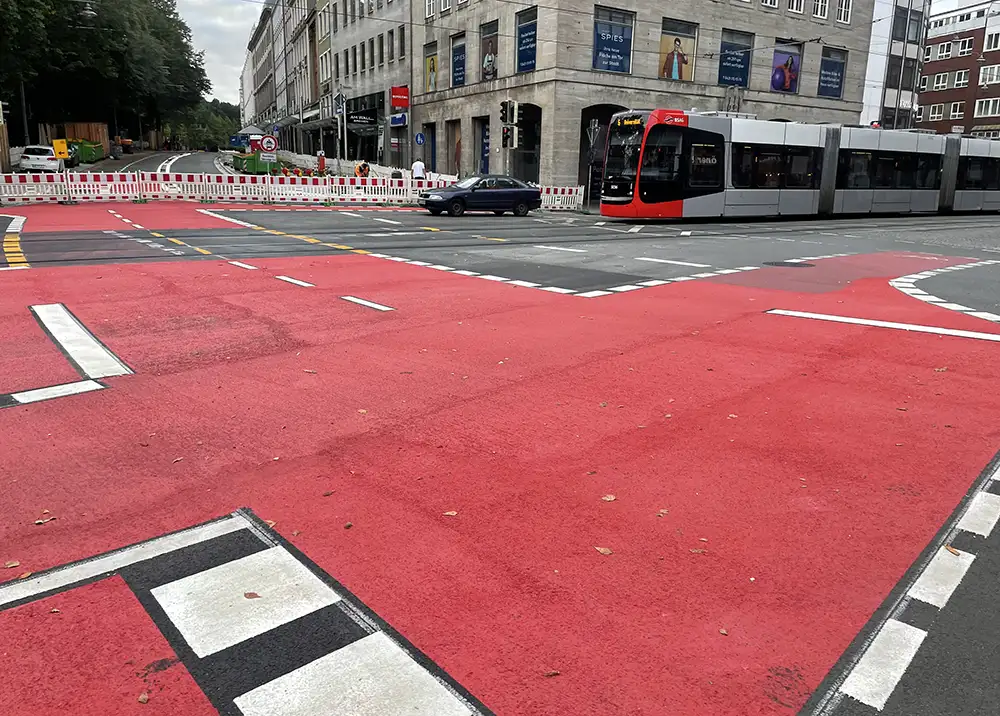 Große Straßenkreuzung mit großflächig aufgemalten roten Fahrradbereichen