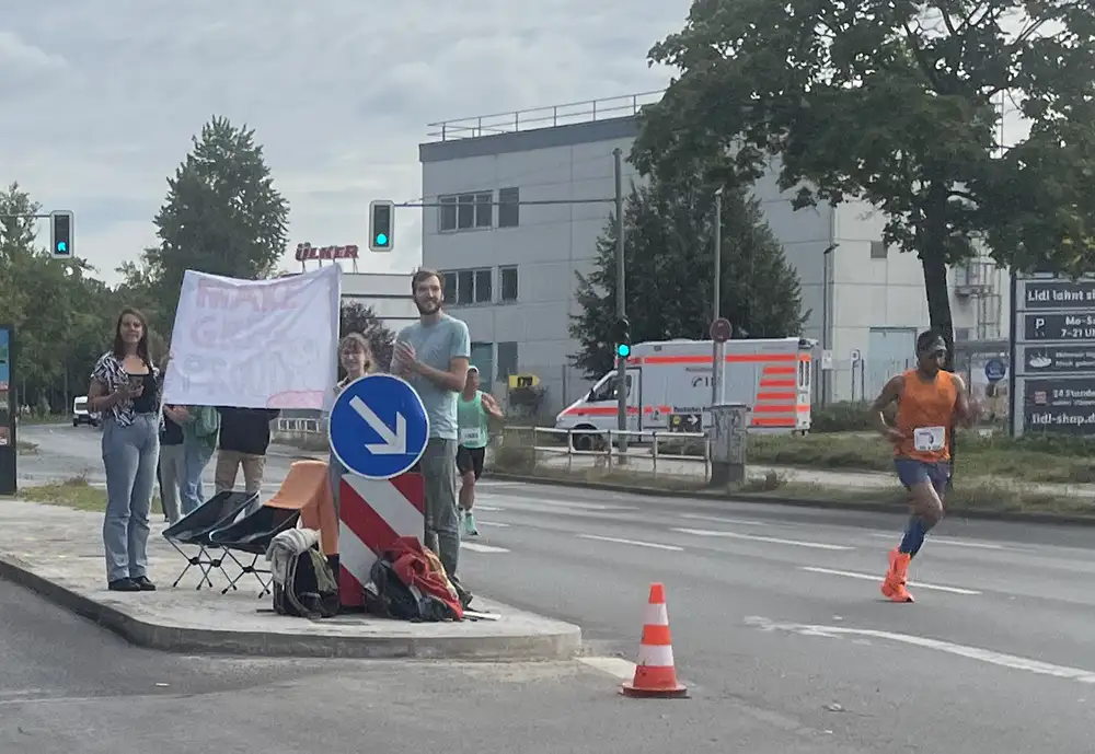 Unterstützer mit selbsgemaltem Banner auf einer Verkehrsinsel