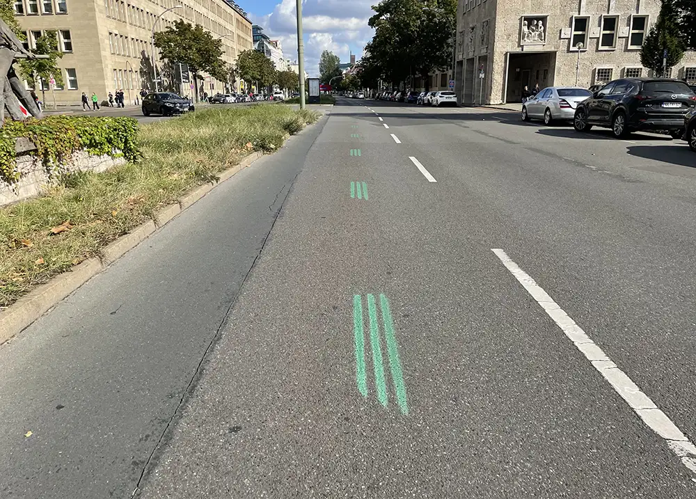 Grüne 3er-Streifen eines Laufevents auf dem Asphalt einer leeren Straße