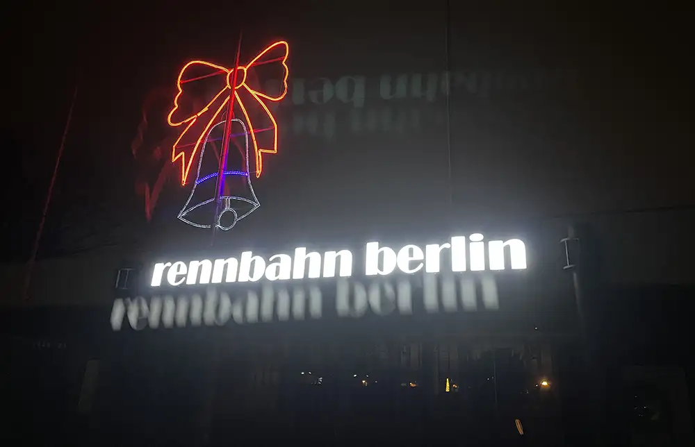 Leuchtschriftzug Rennbahn Berlin mit einer leuchtenden Weihnachts-Glocken-Grafik