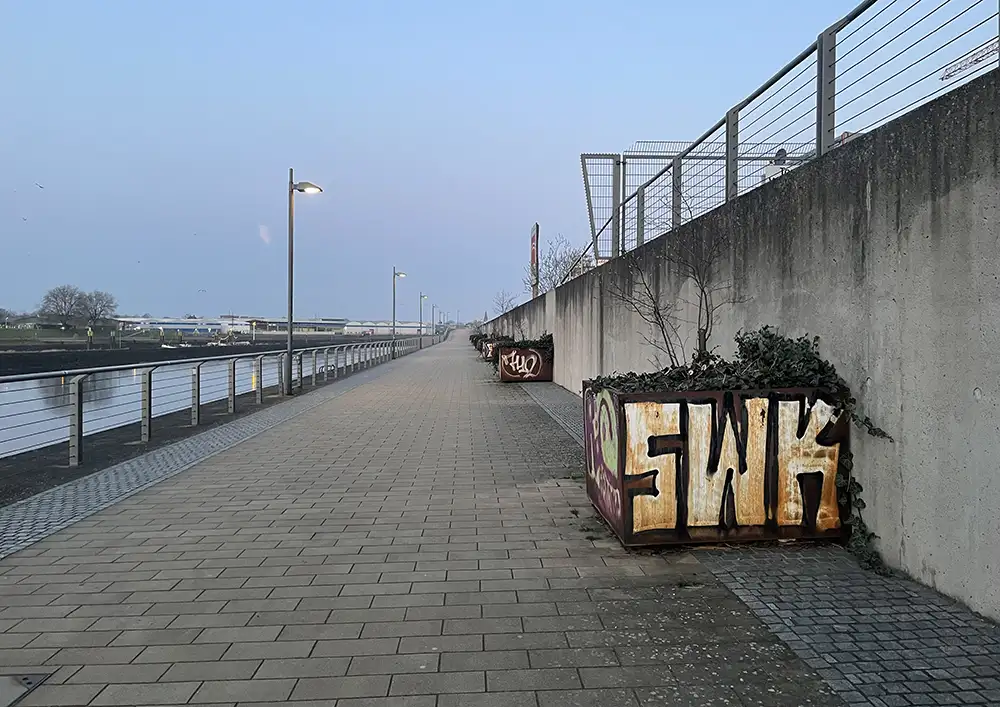 Weserbahnhof-Promenade mit Metall-Pflanzkübeln, die mit Graffiti beschmiert sind