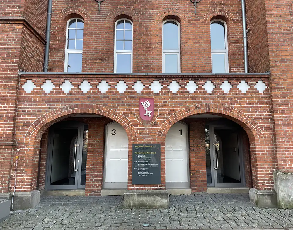Backsteinfassade mit Rundbögen, in der Mitte der Bremer Schlüssel auf rotem Wappengrund