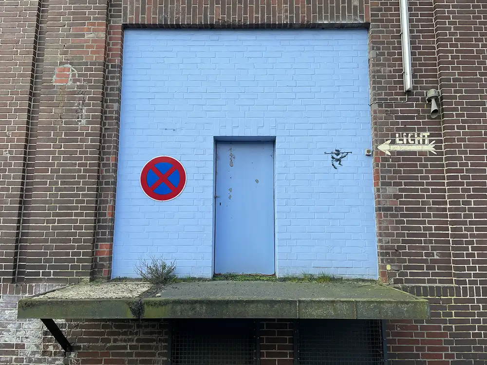 Hellblau gestrichener Türbereich an einem dunklen Backsteingebäude