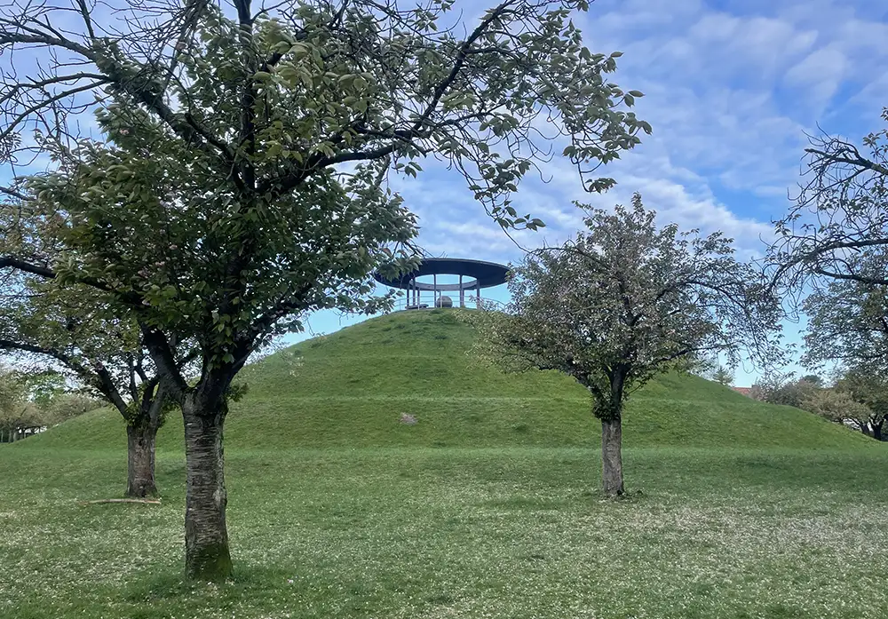 Lilienthal-Denkmal auf Hügel, davor verblühte Kirschbäume