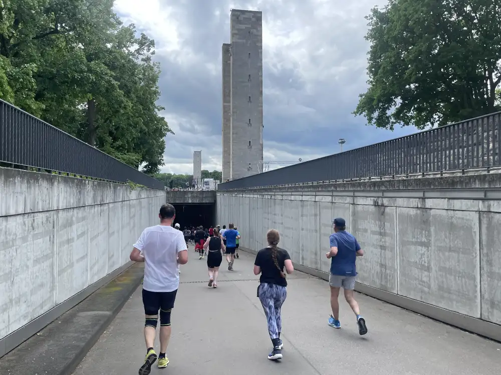 Läuferinnen und Läufer auf der nach unten führenden Einfahrt zur Tiefgarage des Olympiastadions